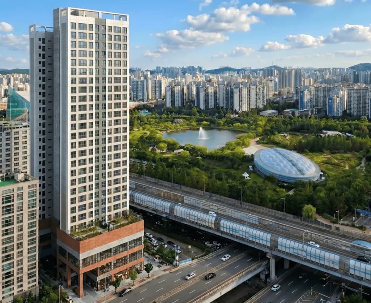 상동역 힐사이드 어반시티 주간 항공 조감도 — 단지 동측 공원의 호수와 돔형 체육시설, 7호선 고가 선로가 함께 보이는 전경