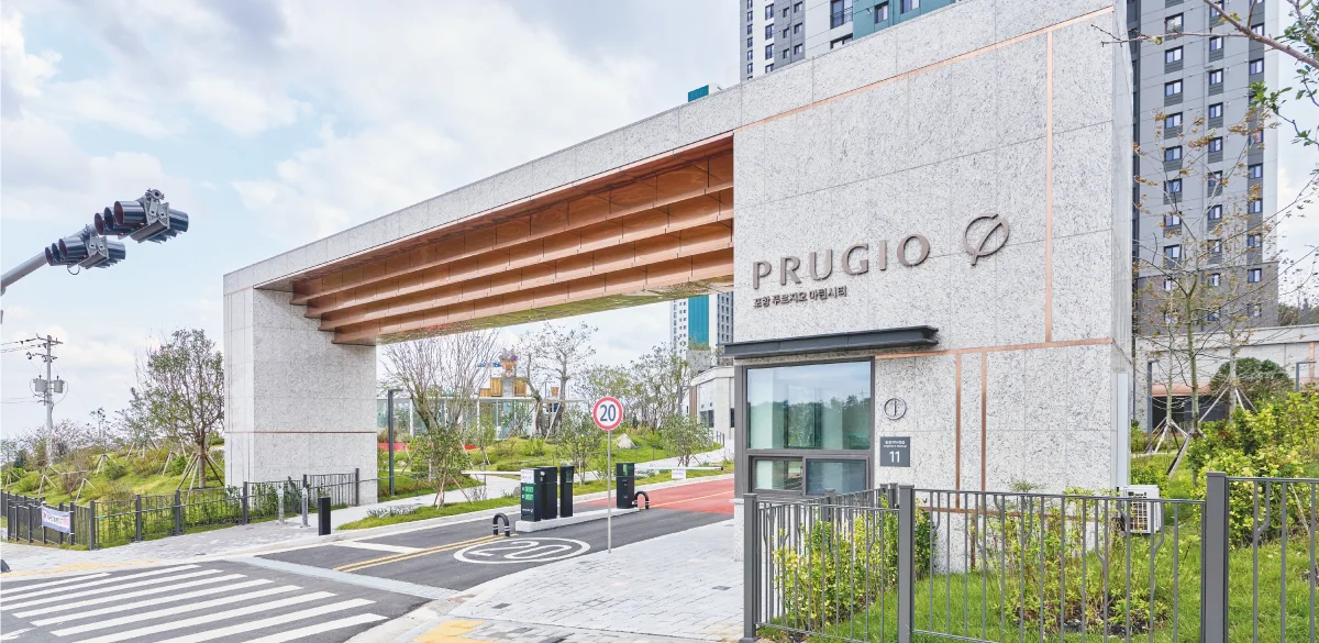 포항 푸르지오 마린시티 단지 문주 실제 사진 — PRUGIO 사인과 목재 루버 천장